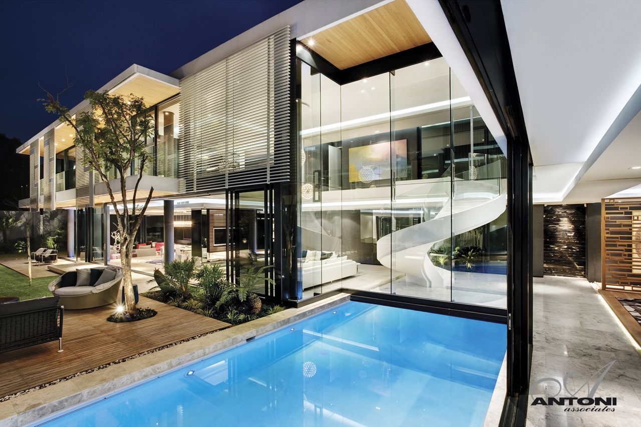 Swimming pool and glass wall as part of facade at night