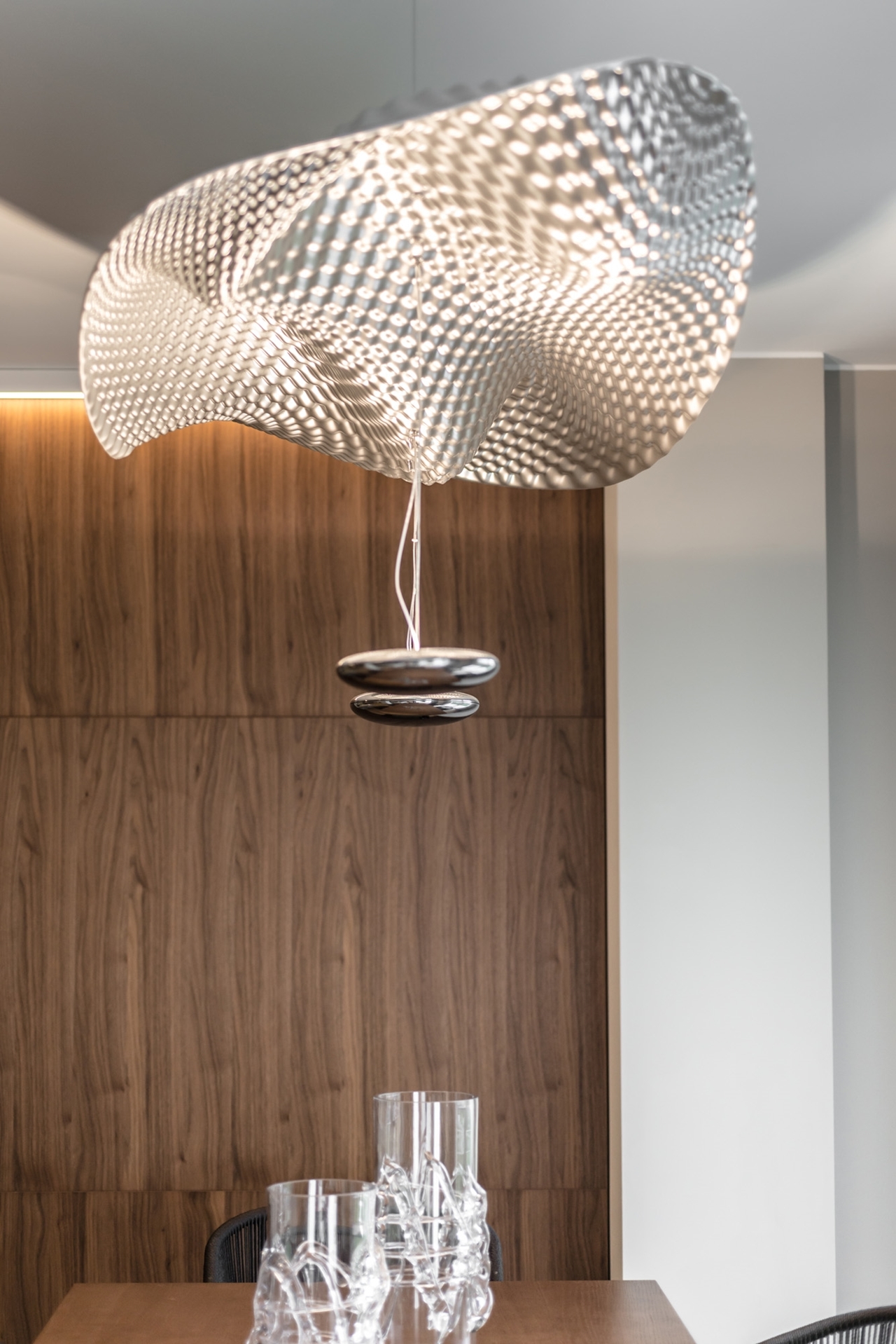 Chandelier above dining table by NG Studio