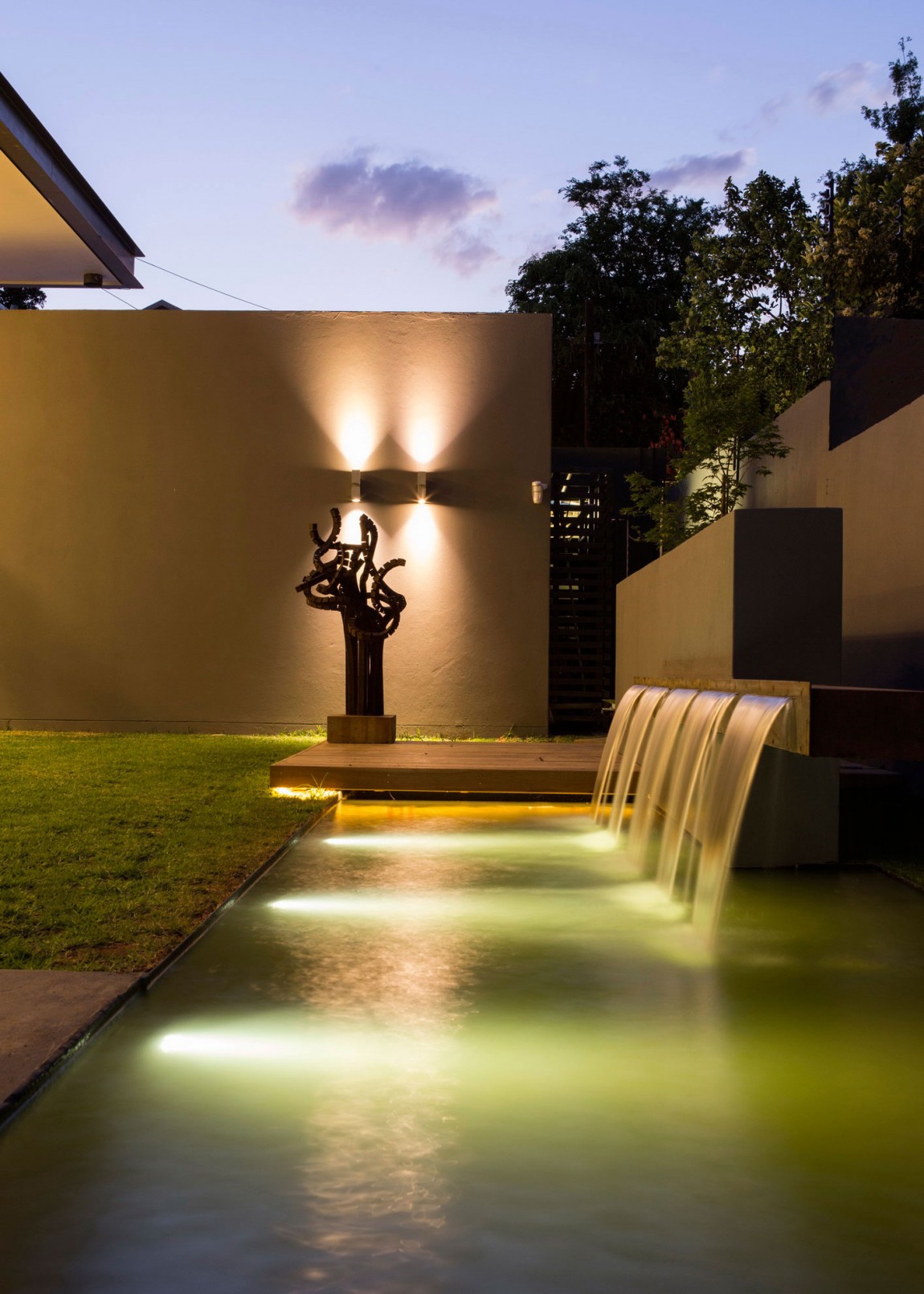 Outdoor swimming pool at night in House Sar by Nico van der Meulen Architects