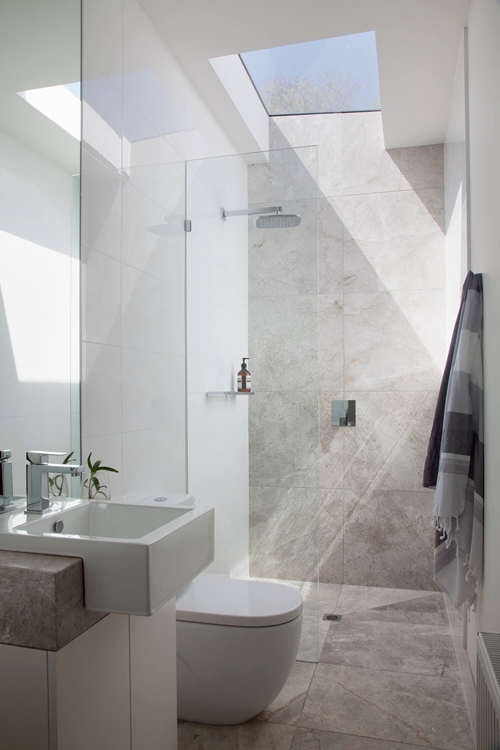 walk in shower in small bathroom with skylight