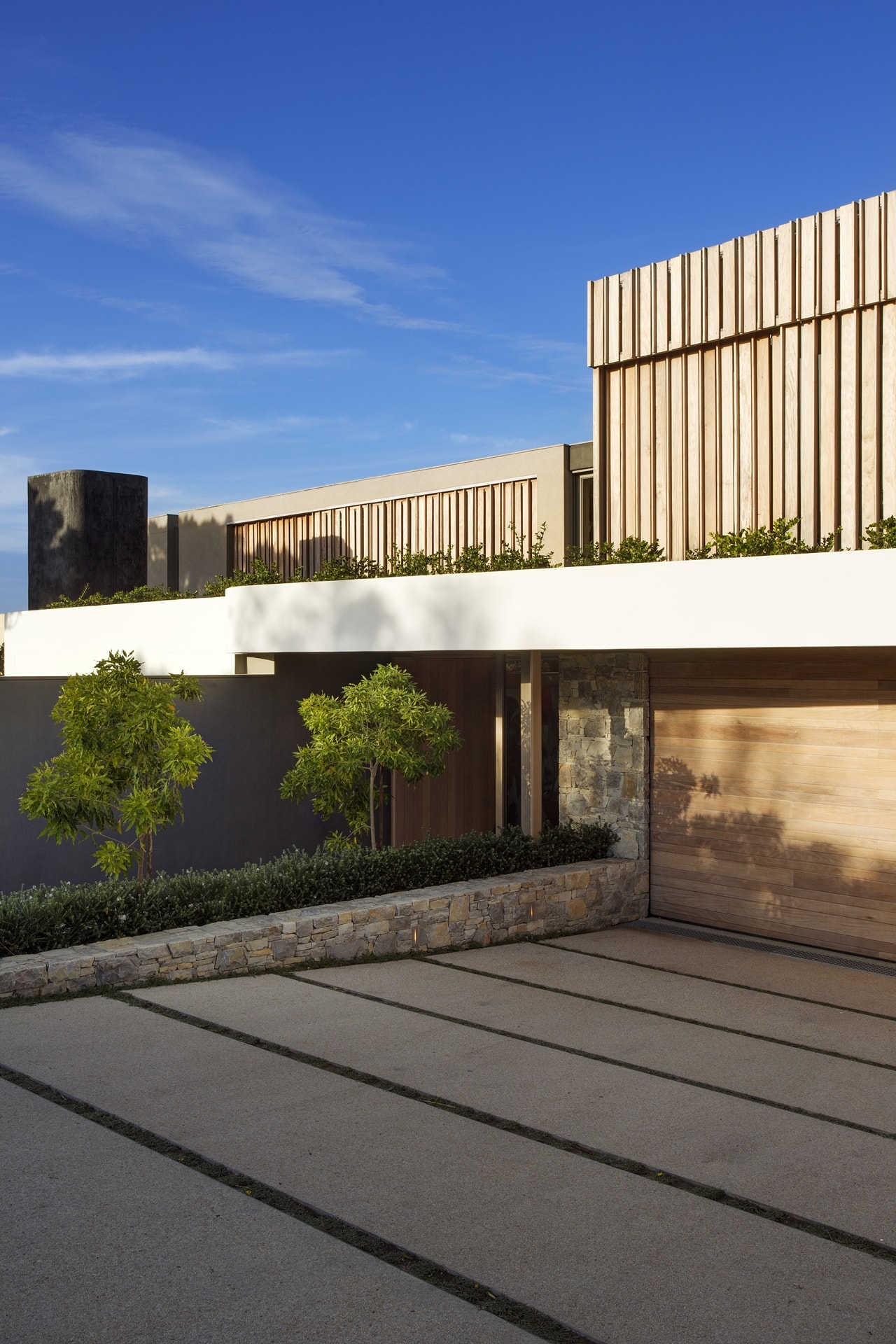 Entrance to the modern home with modern home with wooden facade by SAOTA