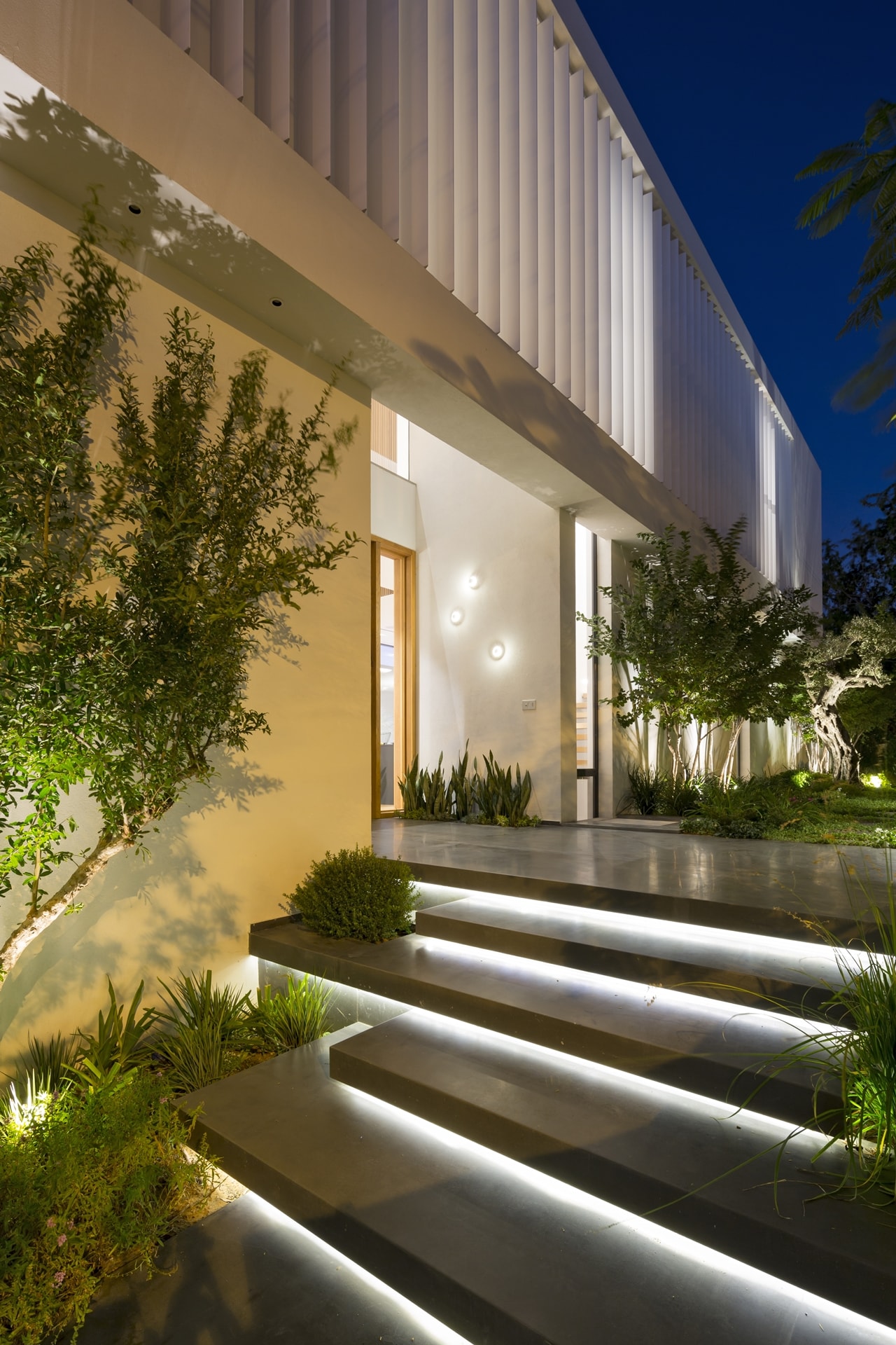 Modern entrance design with lit staircase