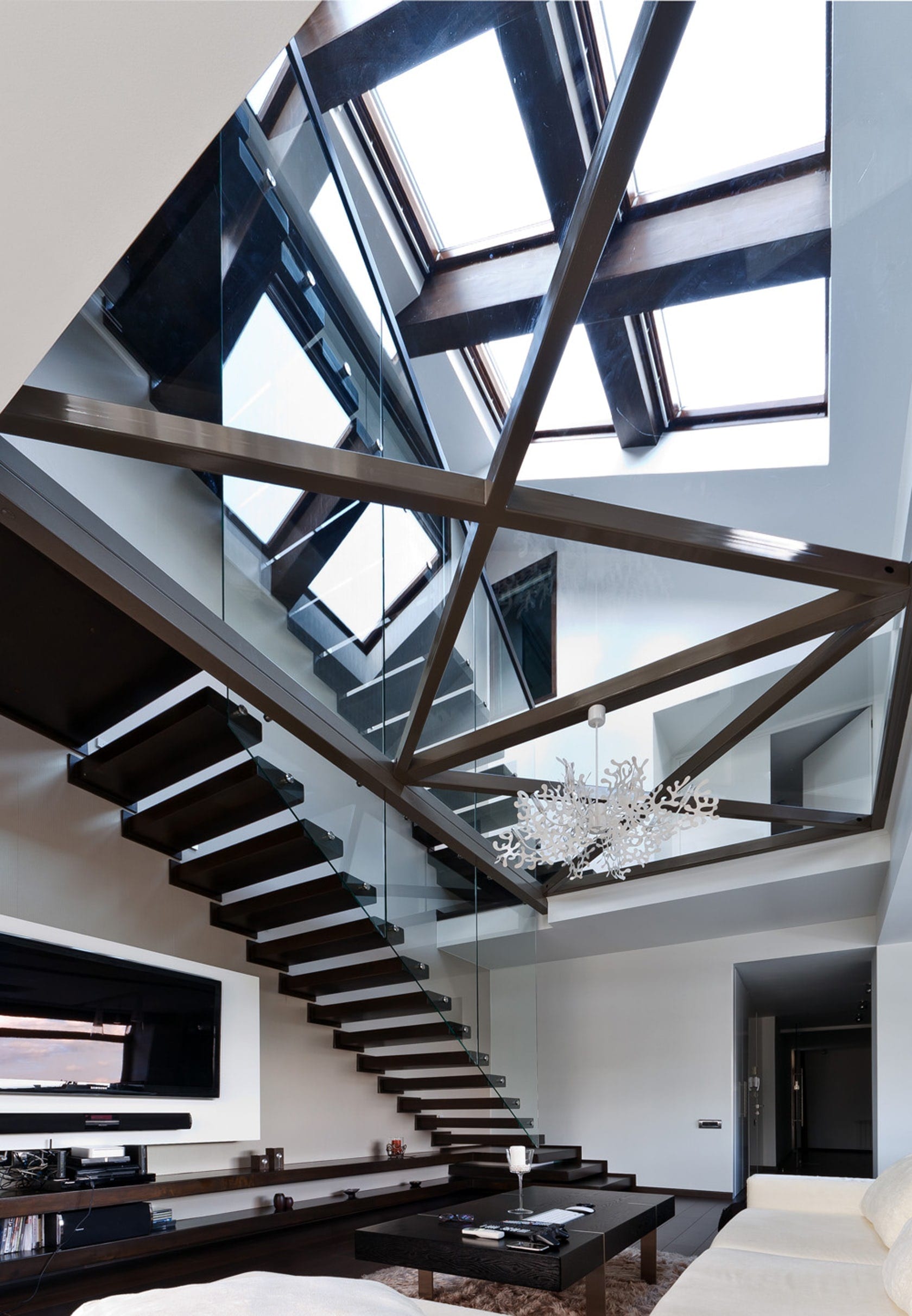 Glass floor design and living room with staircase in modern triplex apartment