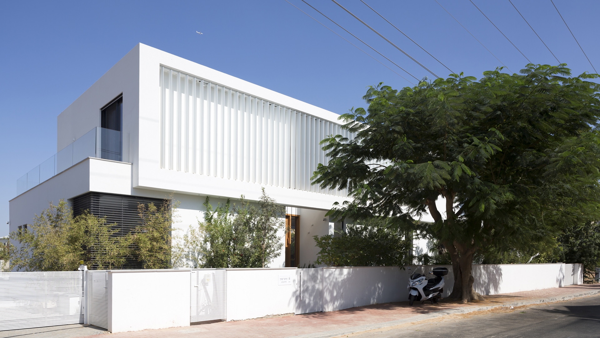 White facade of modern LB house by Shachar Rozenfeld Architects