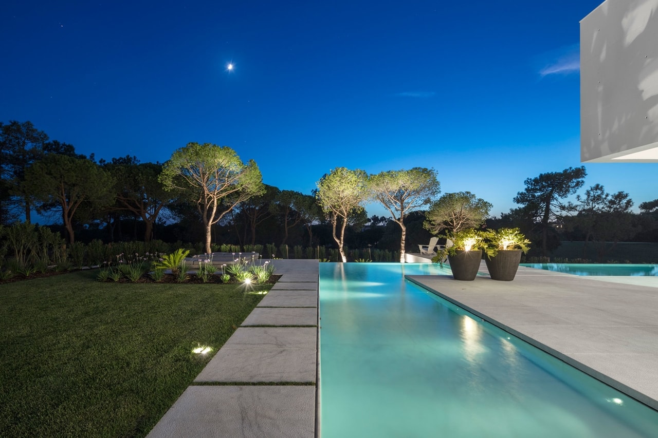 Swimming pool at night in modern home designed by Visioarq