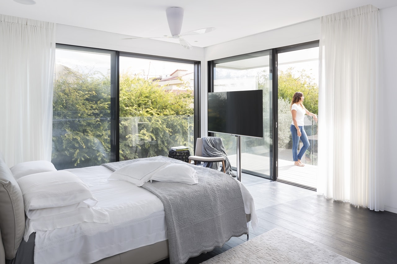 Modern bedroom with glass walls in simple modern home by Sachar-Rozenfeld Architects