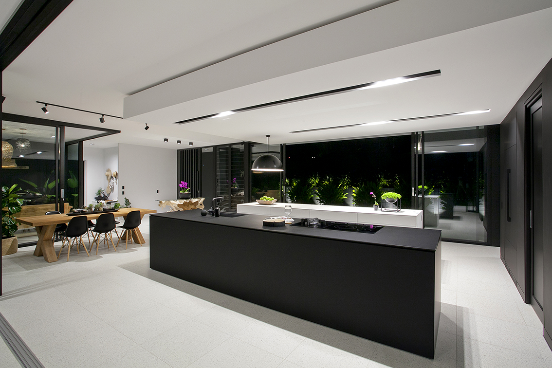Open concept floor plan and black and white kitchen in Glasshouse by Sarah Waller