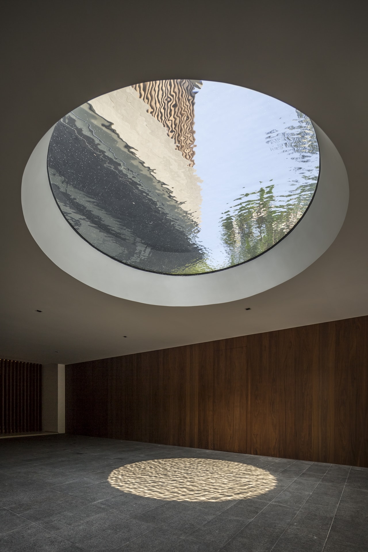 Round skylight above the driveway in modern mansion designed by Wallflower Architecture and Design