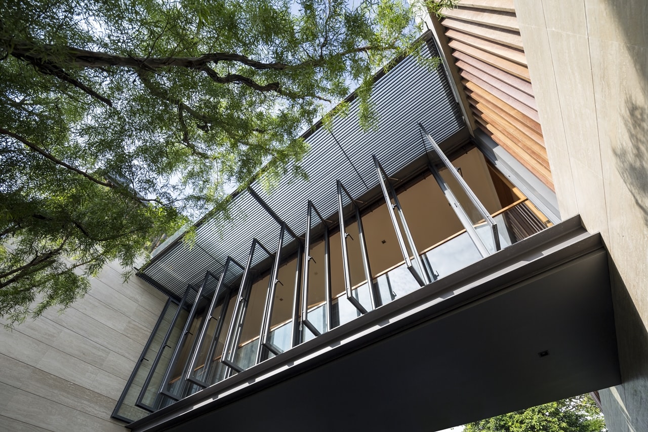 Glass bridge on the first floor of modern mansion designed by Wallflower Architecture and Design