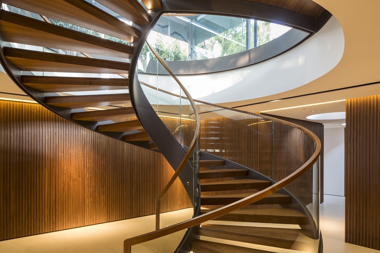 Wooden spiral stairs in modern mansion designed by Wallflower Architecture and Design