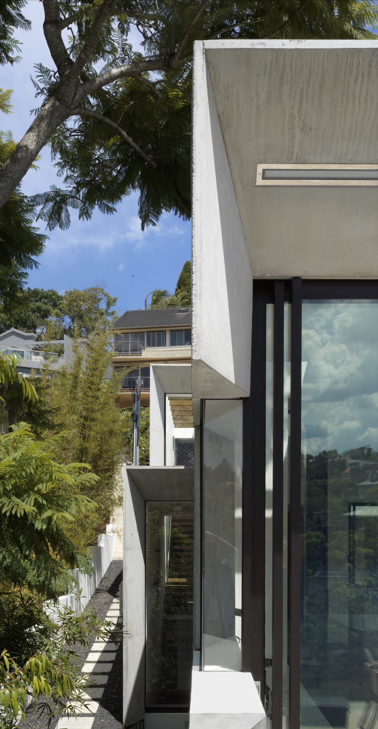 Concrete and glass facade on the hillside house designed by Rolf Ockert