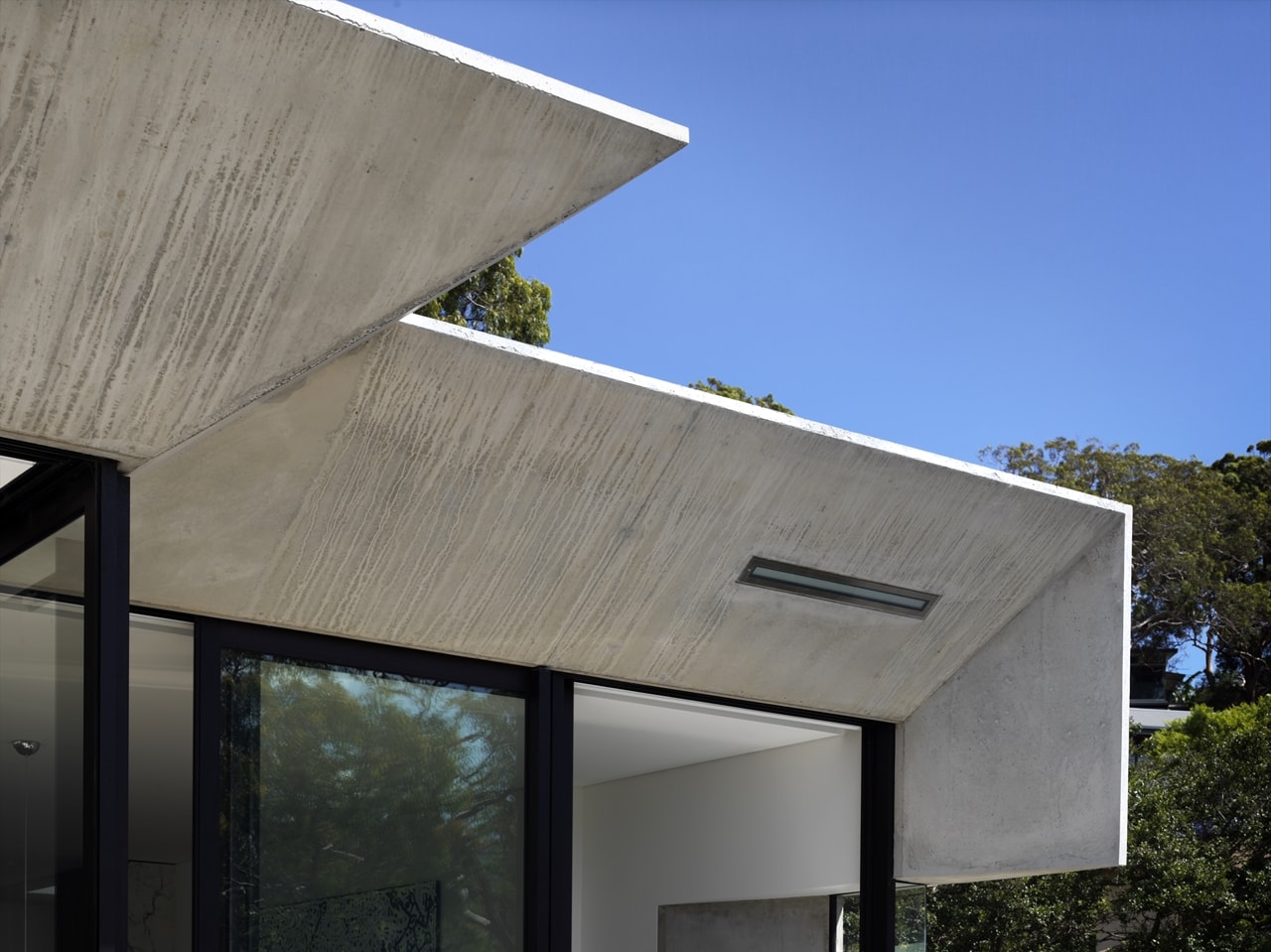 Exposed concrete exterior on the hillside house designed by Rolf Ockert