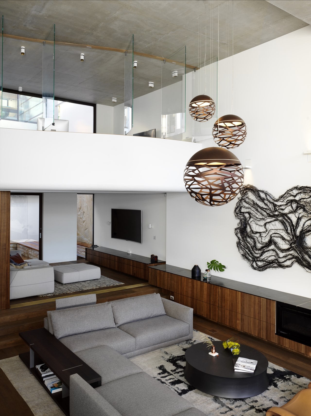 Double height living room with interior glass walls in hillside house designed by Rolf Ockert