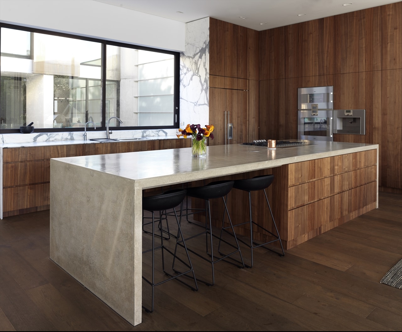 Open concept kitchen with large kitchen island in hillside house designed by Rolf Ockert