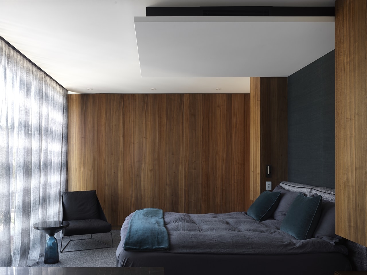 Dark grey bedroom in a hillside house designed by Rolf Ockert