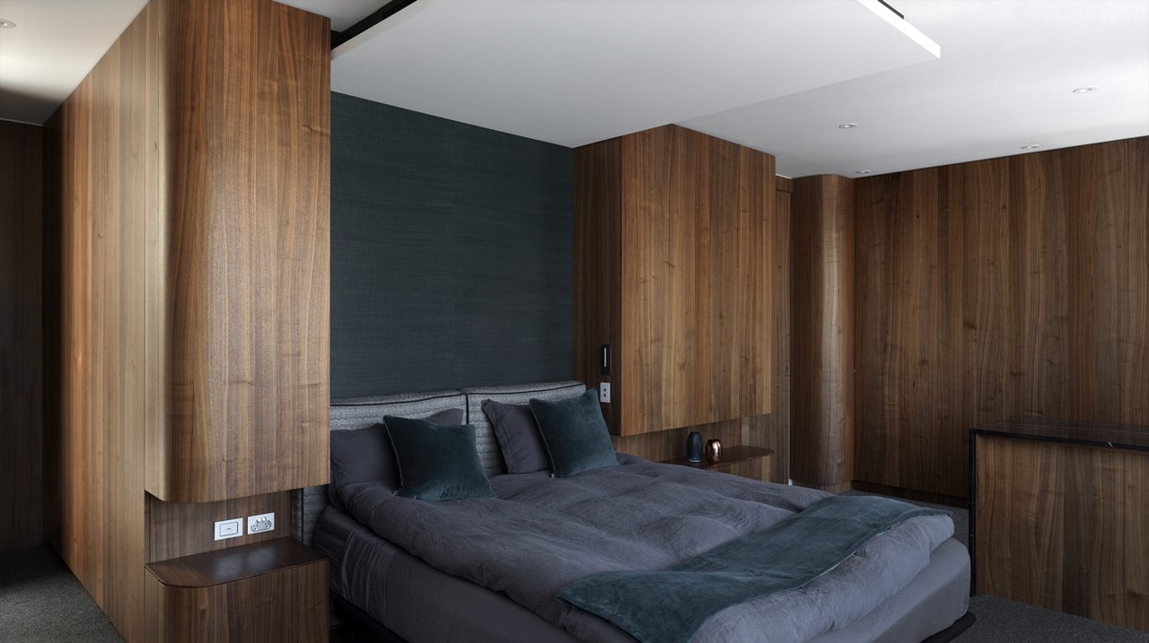Dark bedroom in a hillside house designed by Rolf Ockert